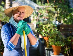 Portrait of happy mature female gardener at botanical garden